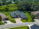 Aerial view of a single Gathering home with lush landscaping and a brick driveway in a desirable neighborhood near a pond at 34652 Heavenly Ln, Dade City, FL 33525