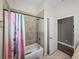 Cozy bathroom featuring a tiled shower and tub combo with light fixtures at 34652 Heavenly Ln, Dade City, FL 33525