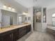 This bathroom offers dual sinks, granite countertops, a separate shower, and a tub at 34652 Heavenly Ln, Dade City, FL 33525