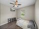 Bedroom with wood floors, ceiling fan, and mounted TV, providing a cozy and modern feel at 34652 Heavenly Ln, Dade City, FL 33525