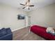 Bedroom with mounted TV, ceiling fan, providing a relaxing and functional space at 34652 Heavenly Ln, Dade City, FL 33525
