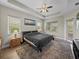 Primary bedroom features a tray ceiling, ceiling fan, and natural light at 34652 Heavenly Ln, Dade City, FL 33525