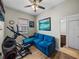 Bright bonus room featuring a comfortable blue couch and exercise equipment at 34652 Heavenly Ln, Dade City, FL 33525