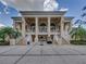 Elegant clubhouse exterior with grand columns, expansive windows, and manicured landscaping at 34652 Heavenly Ln, Dade City, FL 33525