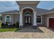 Grand entrance with decorative pillars and a custom front door, complemented by a brick paved walkway at 34652 Heavenly Ln, Dade City, FL 33525