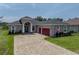 Stunning single Gathering home with a brick driveway and a three-car garage, enhanced by colorful landscaping at 34652 Heavenly Ln, Dade City, FL 33525