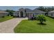 Well-manicured front yard with lush green lawn and a beautiful brick driveway leading to an inviting home at 34652 Heavenly Ln, Dade City, FL 33525