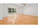 Bright bedroom featuring hardwood floors, ceiling fan and sliding glass doors to a screened in lanai at 3512 Tealwood Cir, Palm Harbor, FL 34685