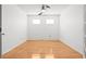 This empty bedroom boasts two windows and hardwood floors at 3512 Tealwood Cir, Palm Harbor, FL 34685