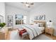 Bright bedroom with a ceiling fan, gray rug, neutral colored bench, and a view from the window at 3512 Tealwood Cir, Palm Harbor, FL 34685
