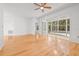Spacious bedroom featuring wood floors, ceiling fan and sliding glass doors to an enclosed patio at 3512 Tealwood Cir, Palm Harbor, FL 34685