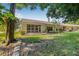 Back of home featuring a paved patio and a serene backdrop of mature trees and landscaping at 3512 Tealwood Cir, Palm Harbor, FL 34685
