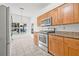 Bright kitchen featuring stainless steel appliances, tiled floor, and wooden cabinets at 3512 Tealwood Cir, Palm Harbor, FL 34685