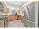 Spacious kitchen with stainless steel appliances, tile floors, and wood cabinets at 3512 Tealwood Cir, Palm Harbor, FL 34685