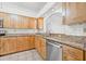 Bright kitchen features wood cabinets, granite countertops, stainless steel dishwasher, and modern tile backsplash at 3512 Tealwood Cir, Palm Harbor, FL 34685