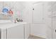 Laundry room with white washer and dryer, metal shelving, and a door at 3512 Tealwood Cir, Palm Harbor, FL 34685
