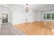 Bright, open-concept living room featuring hardwood floors and a decorative light fixture at 3512 Tealwood Cir, Palm Harbor, FL 34685