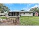 Home exterior featuring a spacious yard, fire pit, screened-in porch, shed, and privacy fence at 3547 55Th N St, St Petersburg, FL 33710