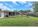The grassy backyard features a fire pit area, screened porch, and lush green lawn at 3547 55Th N St, St Petersburg, FL 33710