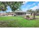 A large, grassy backyard features a fire pit, screened-in porch, boat trailer, and storage shed at 3547 55Th N St, St Petersburg, FL 33710