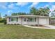 Charming single-story home with gray exterior, well-manicured lawn, and welcoming front entrance with tasteful landscaping at 3547 55Th N St, St Petersburg, FL 33710