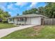 Angle view of a charming single-story home with gray exterior, well-manicured lawn, and a one-car garage at 3547 55Th N St, St Petersburg, FL 33710