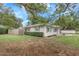 Lovely single-story home with gray exterior, fenced yard, and mature trees offering shade and privacy at 3547 55Th N St, St Petersburg, FL 33710