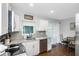 Functional kitchen with stainless steel appliances, white cabinetry, and an adjacent dining area at 3547 55Th N St, St Petersburg, FL 33710