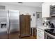 Modern kitchen area with stainless steel fridge and white cabinetry, and stainless trash receptacle at 3547 55Th N St, St Petersburg, FL 33710