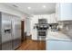 Modern kitchen with stainless steel refrigerator, white cabinets, and a sleek stainless steel oven at 3547 55Th N St, St Petersburg, FL 33710