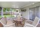 Enclosed patio featuring a cozy seating area, glass table, and seamless access to the backyard at 3547 55Th N St, St Petersburg, FL 33710