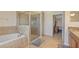 Bright bathroom with a shower, tub, and tiled floors, with a bedroom entrance at 3862 Tristram Loop, Land O Lakes, FL 34638