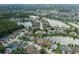 Aerial shot shows the property with a pool, nestled within a lakeside community with mature trees and well-kept streets at 4228 Savage Station Cir, New Port Richey, FL 34653