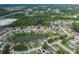 A picturesque aerial view of a suburban community featuring homes near a tranquil lake and wooded areas at 4228 Savage Station Cir, New Port Richey, FL 34653