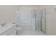 Bright bathroom featuring a shower with glass doors, a soaking tub, and tile flooring at 4228 Savage Station Cir, New Port Richey, FL 34653