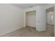 Bedroom with neutral walls and carpet, showing a closet with hanging rod and a door to an adjacent hallway at 4228 Savage Station Cir, New Port Richey, FL 34653