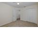 Bedroom showing neutral walls, carpet flooring, a ceiling fan, closet, and an adjacent hallway at 4228 Savage Station Cir, New Port Richey, FL 34653