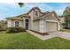 Charming two-story home featuring a two-car garage, landscaped yard, and inviting front entrance at 4228 Savage Station Cir, New Port Richey, FL 34653