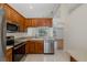 Well-lit kitchen featuring stainless steel appliances and wood cabinets in a home with an open floor plan at 4228 Savage Station Cir, New Port Richey, FL 34653