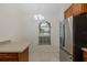 Eat-in kitchen features stainless steel refrigerator, tile flooring, wood cabinets and a window view at 4228 Savage Station Cir, New Port Richey, FL 34653