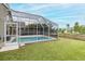 This home features a screened in pool and a well-maintained lawn with a fenced in yard at 4228 Savage Station Cir, New Port Richey, FL 34653