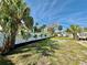 Expansive backyard bordered by a white fence and lush palm trees, offering privacy at 440 89Th Ave, St Pete Beach, FL 33706