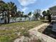 Spacious backyard featuring a white fence, mature trees, and some grass at 440 89Th Ave, St Pete Beach, FL 33706