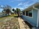 A view of the backyard, showing the side of the house with a sidewalk at 440 89Th Ave, St Pete Beach, FL 33706