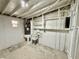 Unfinished basement area with concrete floor, water heater and shelving at 440 89Th Ave, St Pete Beach, FL 33706