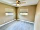 A clean, neutral bedroom with ceiling fan, window, and sleek tile floors at 440 89Th Ave, St Pete Beach, FL 33706