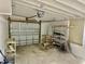View of the garage, with garage door, concrete floor, shelving and unfinished walls at 440 89Th Ave, St Pete Beach, FL 33706