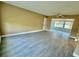 Bright living room with grey wood-look tile floors and a view to the sunroom through a large opening at 440 89Th Ave, St Pete Beach, FL 33706