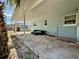 Covered patio featuring a comfortable outdoor seating arrangement and a neatly paved brick floor for relaxation at 440 89Th Ave, St Pete Beach, FL 33706