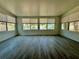 Inviting sunroom filled with natural light with beautiful grey wood-look tile flooring and large windows at 440 89Th Ave, St Pete Beach, FL 33706